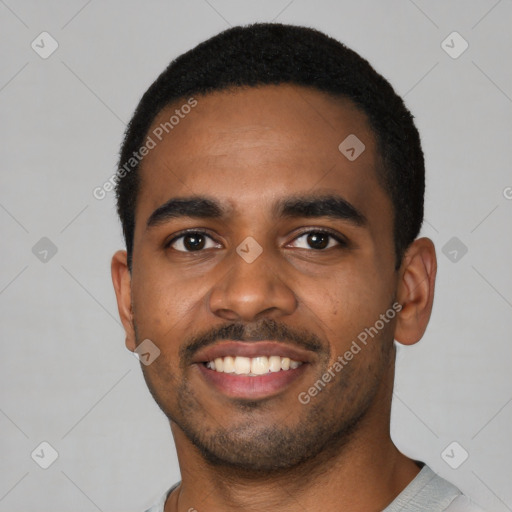 Joyful black young-adult male with short  black hair and brown eyes