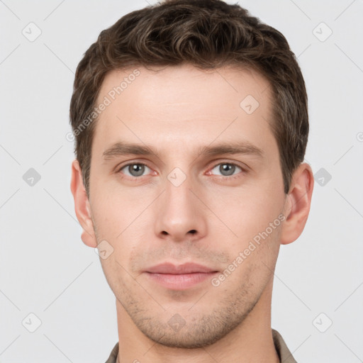 Joyful white young-adult male with short  brown hair and grey eyes