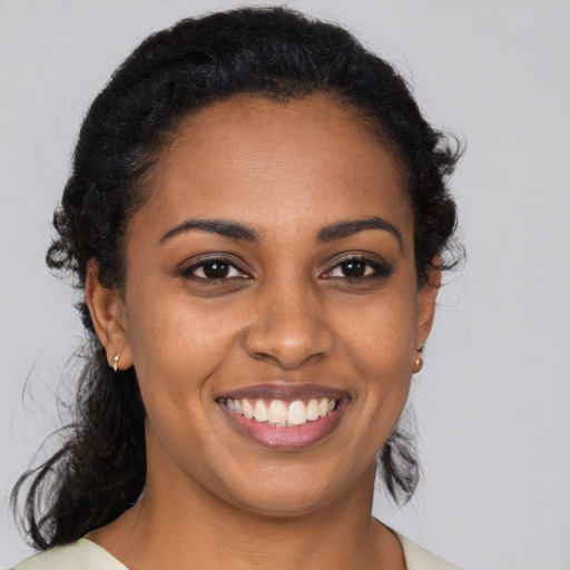 Joyful black young-adult female with medium  black hair and brown eyes