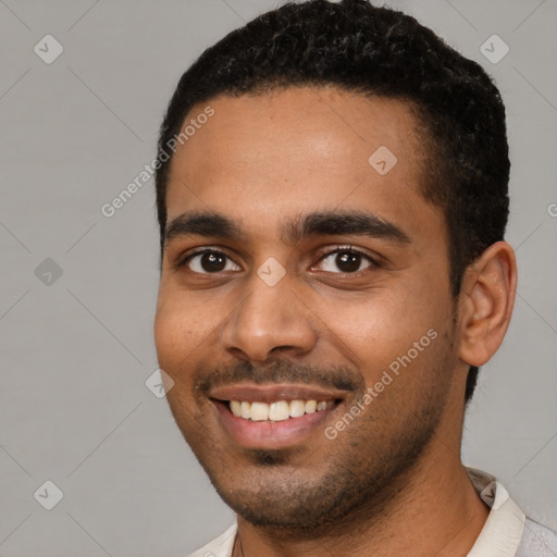 Joyful black young-adult male with short  black hair and brown eyes