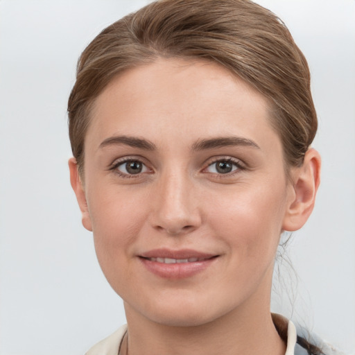 Joyful white young-adult female with short  brown hair and grey eyes