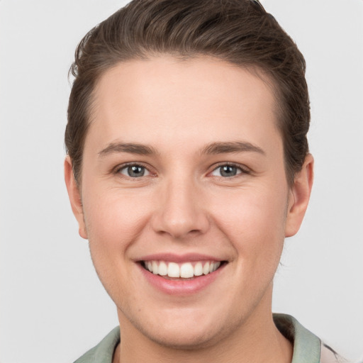 Joyful white young-adult female with short  brown hair and grey eyes