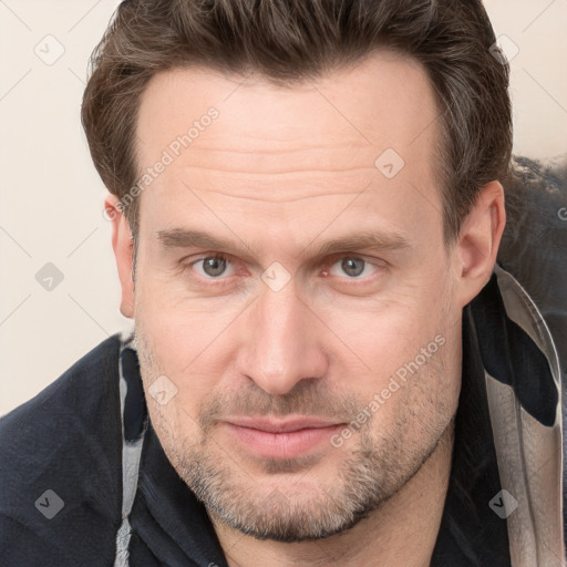 Joyful white adult male with short  brown hair and grey eyes