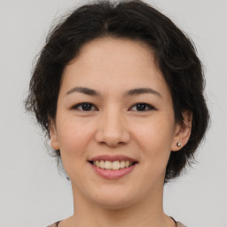 Joyful asian young-adult female with short  brown hair and brown eyes