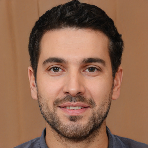 Joyful white young-adult male with short  black hair and brown eyes