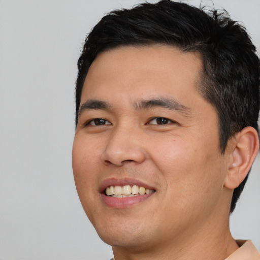 Joyful asian young-adult male with short  brown hair and brown eyes