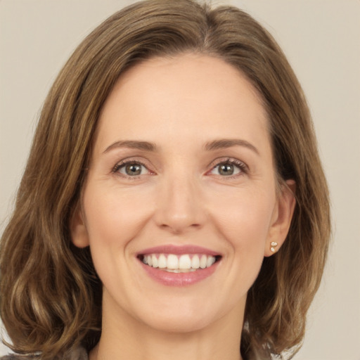 Joyful white young-adult female with medium  brown hair and green eyes