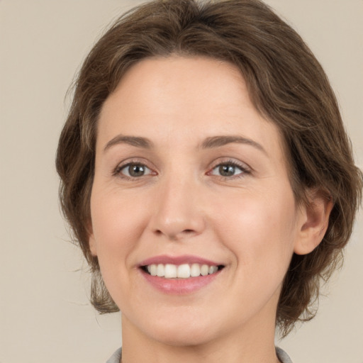 Joyful white young-adult female with medium  brown hair and green eyes