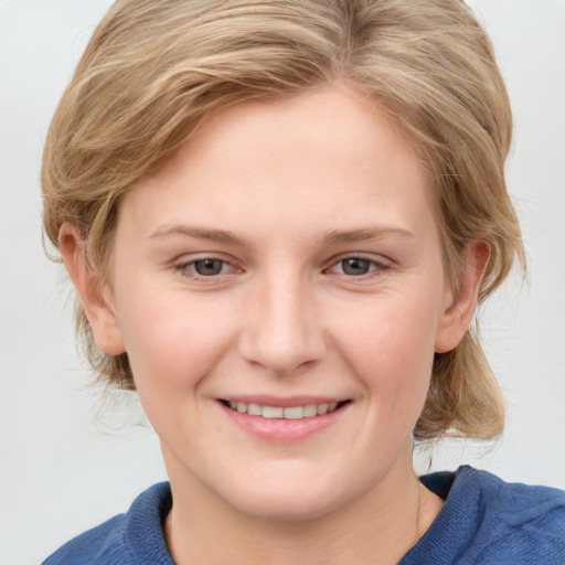 Joyful white young-adult female with medium  brown hair and blue eyes