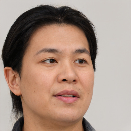 Joyful asian adult male with short  brown hair and brown eyes