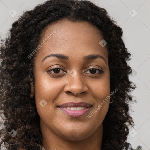 Joyful black young-adult female with long  brown hair and brown eyes