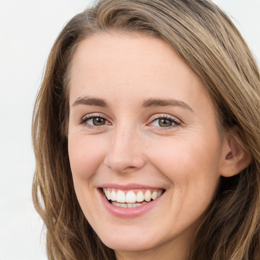 Joyful white young-adult female with long  brown hair and green eyes