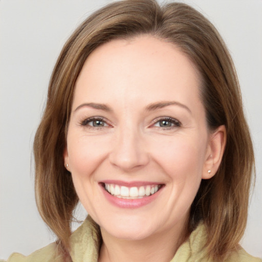 Joyful white adult female with medium  brown hair and grey eyes