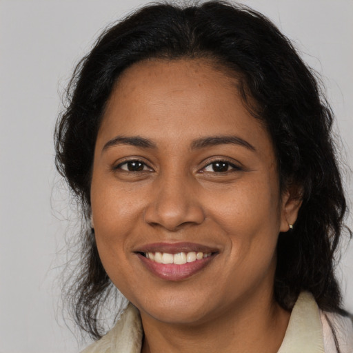 Joyful latino adult female with medium  brown hair and brown eyes