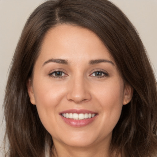 Joyful white young-adult female with long  brown hair and brown eyes