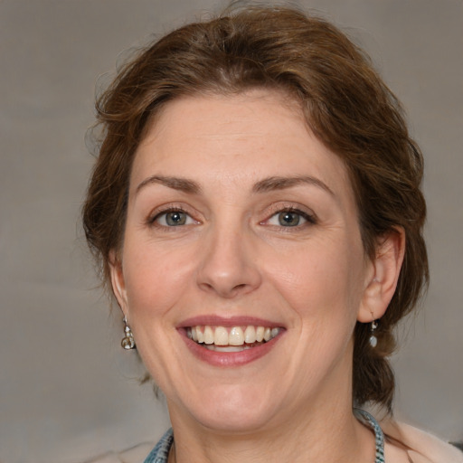 Joyful white adult female with medium  brown hair and blue eyes