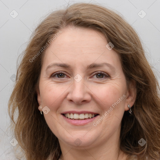 Joyful white adult female with long  brown hair and grey eyes