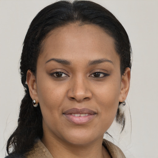Joyful black young-adult female with long  brown hair and brown eyes