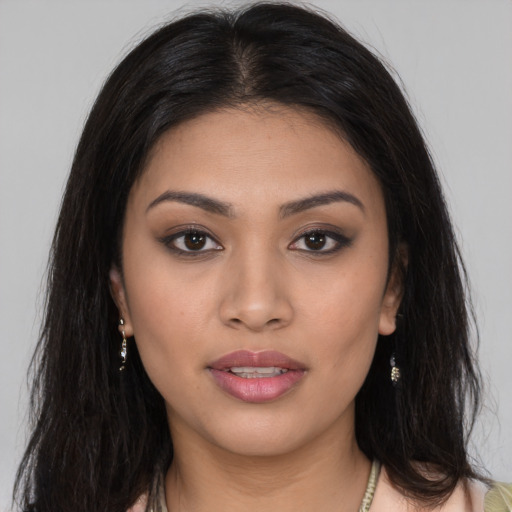 Joyful latino young-adult female with long  brown hair and brown eyes