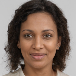 Joyful black adult female with long  brown hair and brown eyes