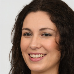 Joyful white adult female with long  brown hair and brown eyes