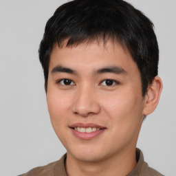 Joyful asian young-adult male with short  brown hair and brown eyes