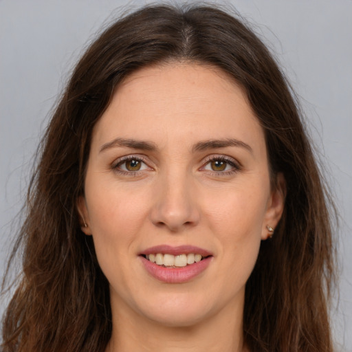 Joyful white young-adult female with long  brown hair and brown eyes