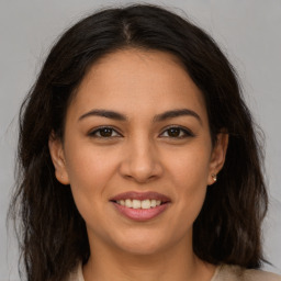 Joyful latino young-adult female with long  brown hair and brown eyes