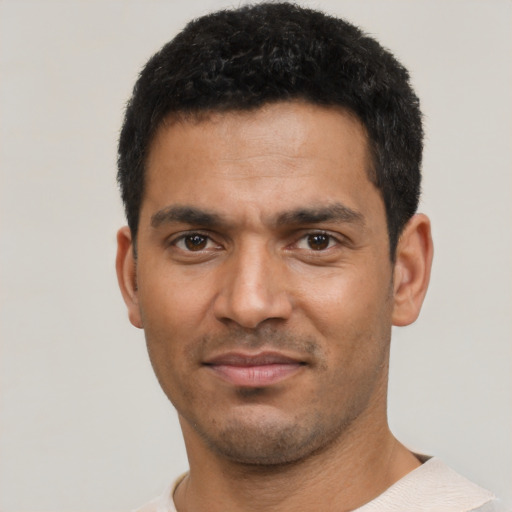 Joyful latino young-adult male with short  black hair and brown eyes