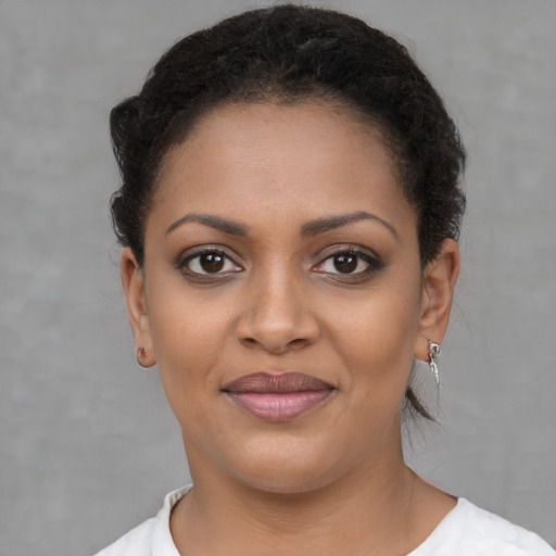 Joyful black young-adult female with short  brown hair and brown eyes