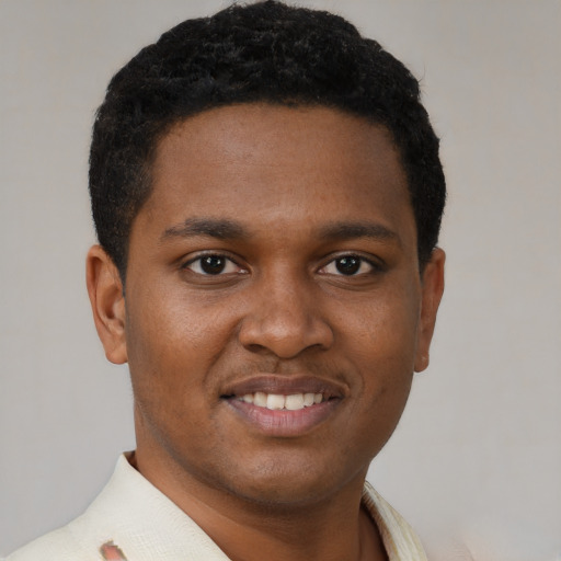 Joyful black young-adult male with short  brown hair and brown eyes
