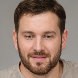 Joyful white young-adult male with short  brown hair and grey eyes