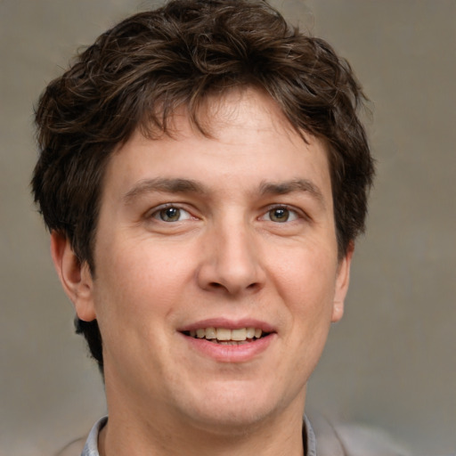 Joyful white adult male with short  brown hair and grey eyes