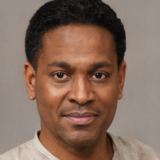 Joyful black adult male with short  black hair and brown eyes