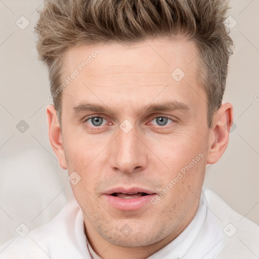 Joyful white young-adult male with short  brown hair and grey eyes