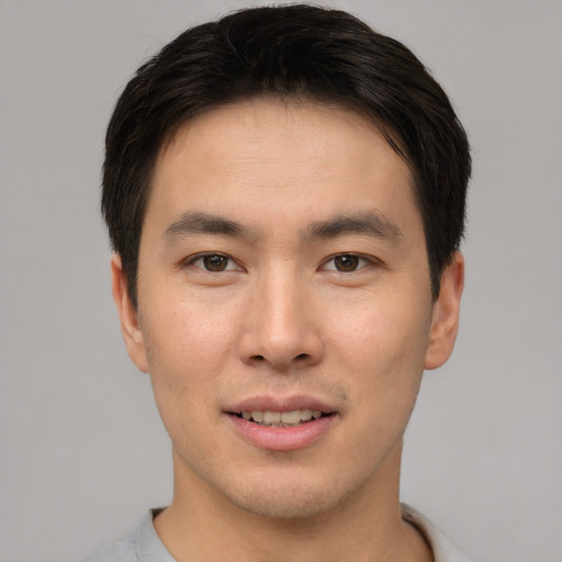 Joyful asian young-adult male with short  brown hair and brown eyes
