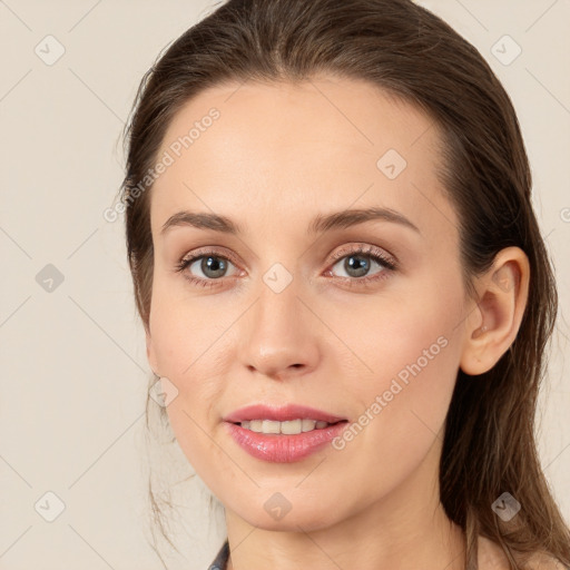 Joyful white young-adult female with long  brown hair and grey eyes