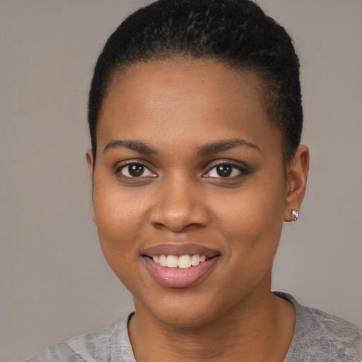 Joyful black young-adult female with short  brown hair and brown eyes