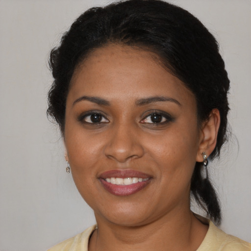 Joyful black young-adult female with medium  brown hair and brown eyes