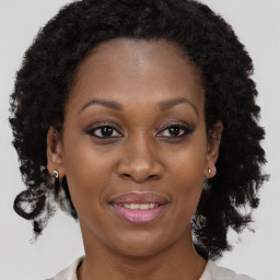 Joyful black adult female with medium  brown hair and brown eyes