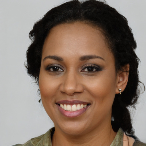 Joyful black young-adult female with medium  black hair and brown eyes