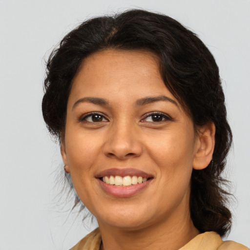 Joyful latino adult female with medium  brown hair and brown eyes