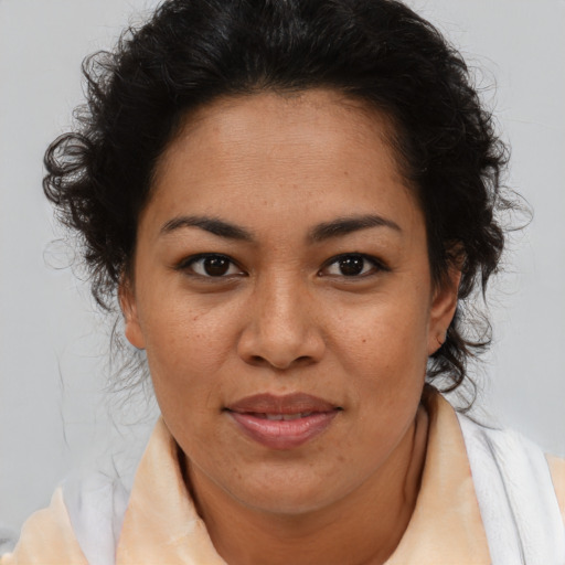 Joyful latino adult female with medium  brown hair and brown eyes
