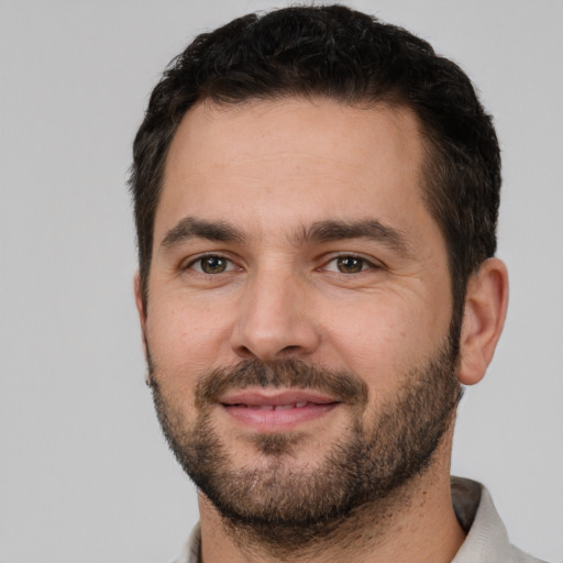 Joyful white young-adult male with short  black hair and brown eyes