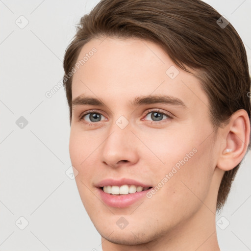 Joyful white young-adult male with short  brown hair and grey eyes