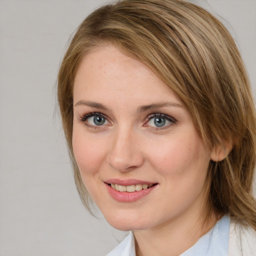 Joyful white young-adult female with medium  brown hair and blue eyes