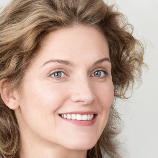 Joyful white young-adult female with medium  brown hair and blue eyes