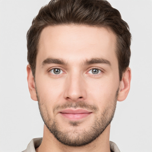 Joyful white young-adult male with short  brown hair and grey eyes