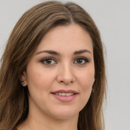 Joyful white young-adult female with long  brown hair and green eyes