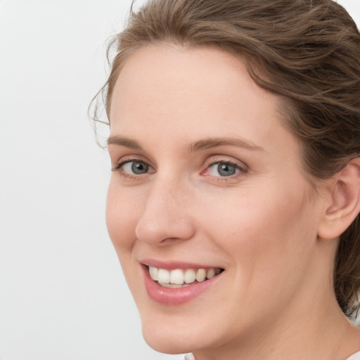 Joyful white young-adult female with medium  brown hair and blue eyes